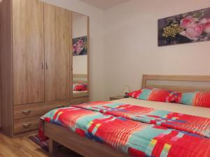 a bedroom with a bed and a dresser and a mirror at Apartmani Predovan in Vrsi