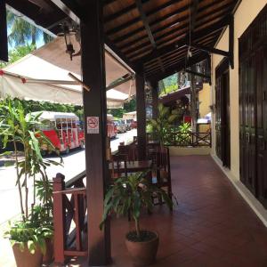 patio ze stołem i krzesłami oraz autobusem w obiekcie Villa Phathana Boutique Hotel w mieście Luang Prabang