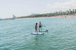 a man and a woman on paddle boards in the water at Hotel Casa Bonay & Spa in Barcelona