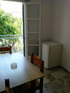 ein Esszimmer mit einem Tisch und einem Kühlschrank in der Unterkunft Panos Studios in Poros