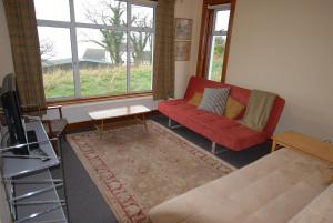 a living room with a red couch and a table at The Hide in Newtownards