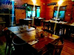 - une grande table en bois dans un restaurant avec des tables et des chaises dans l'établissement Pundak guesthouse, à Moshav Ramot