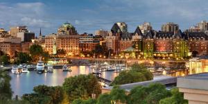 a city skyline with boats in a harbor at night at Best Western PLUS Inner Harbour Hotel in Victoria