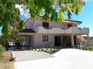a large white house with a driveway at Apartmani Predovan in Vrsi