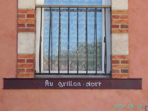 una ventana con una valla de hierro delante de ella en Chambres d'Hôtes Au Grillon Dort, en Moustey