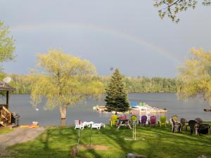 a group of tables and chairs on a lawn near a lake at Ogopogo Resort in Carnarvon