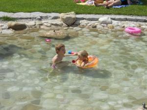 two young children playing in a pool of water at Reiters-Ferienhaus in Russbach am Pass Gschütt