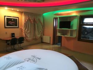 Zimmer mit einem Bett, einem TV und einem Tisch in der Unterkunft Motel Monza (Adults Only) in Farroupilha