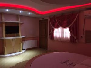 ein Wohnzimmer mit einer roten Decke in der Unterkunft Motel Monza (Adults Only) in Farroupilha