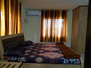 a bedroom with a bed and a window at Aakriti NS71 in Bhopal