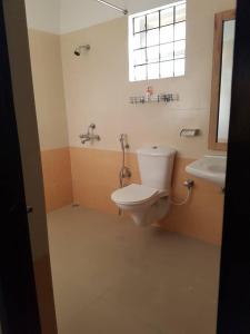 ein Bad mit einem WC, einem Waschbecken und einem Fenster in der Unterkunft Aakriti NS71 in Bhopal