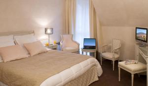 Postel nebo postele na pokoji v ubytování Logis Hotel Le Parc & Spa