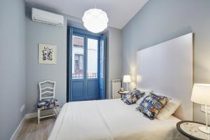 1 dormitorio con 1 cama grande y puerta azul en LEEWAYS APARTMENT in FÚCAR, en Madrid