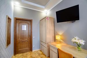 Zimmer mit einem Schreibtisch und einem TV an der Wand in der Unterkunft Premium Hostel in Lwiw