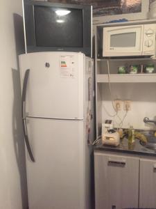 a white refrigerator in a kitchen with a microwave at Apartamento aire acondicionado, wifi, Netflix,cerca de la Playa Mansa y Centro Maldonado in Maldonado