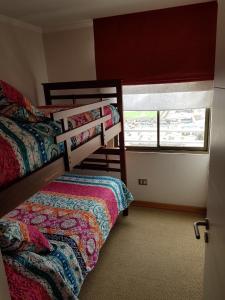 a bedroom with two bunk beds and a window at Mar Egeo in Iquique