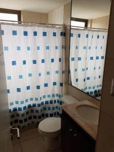 ein Badezimmer mit einem WC, einem Waschbecken und einem Spiegel in der Unterkunft Mar Egeo in Iquique