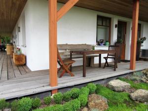 eine Terrasse mit einem Tisch und Stühlen auf einem Haus in der Unterkunft Qi Gong Haus in Roßdorf