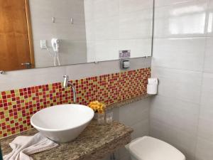 a bathroom with a sink and a toilet at Hotel do Reinildo I in Cachoeira Paulista +17 photos