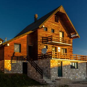 una grande casa in legno con un ampio ponte di Guesthouse Wolf a Žabljak