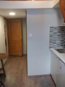 eine Küche mit weißen Arbeitsflächen und einer Holztür in der Unterkunft Green Panda Apartments in Budapest