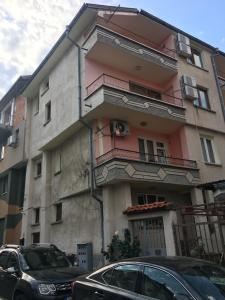 a building with cars parked in front of it at Daniel Guest House in Nesebar