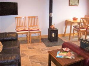a living room with chairs and a wood stove at Homestead Stables in Market Lavington