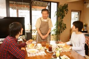 札幌市にあるサッポロイン NADAの食卓前に立って食べ物を食べる男