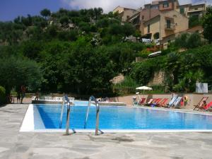 een zwembad met stoelen en parasols ernaast bij Casa Vacanze Mombrino in Finale Ligure