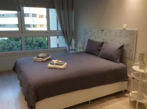 a bedroom with a large bed with towels on it at The Central Suites in Nicosia