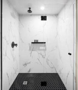 a bathroom with a shower with white marble walls at The Broadview Hotel in Toronto