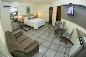 a living room with a bed and a couch at Hotel Apolo XVI in Criciúma