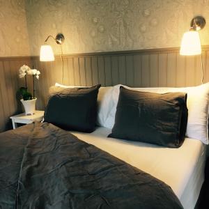 a bed with two pillows on it in a room at Villamilsten B&B in Lidköping