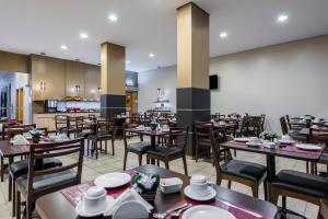 a restaurant with tables and chairs and a kitchen at Sleep Inn Manaus in Manaus