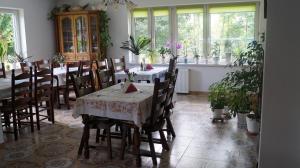 a dining room with a table and chairs and windows at Agroturystyka Stokrotka in Rymanów-Zdrój