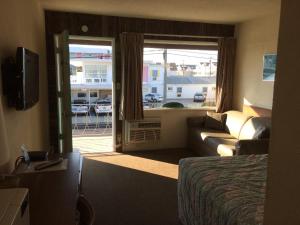 a hotel room with a bed and a couch and a window at Crystal Sands Motel in Wildwood