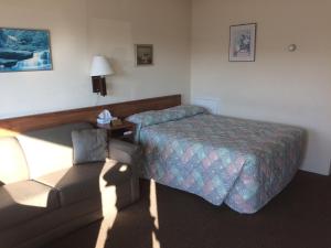 um quarto de hotel com uma cama e um sofá em Crystal Sands Motel em Wildwood