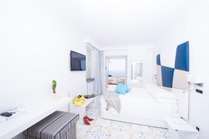 a white living room with a white couch and blue accents at Hotel Villa Felice Relais in Amalfi