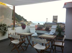 eine Terrasse mit Tischen und Stühlen auf dem Balkon in der Unterkunft SoleMare in Monterosso al Mare