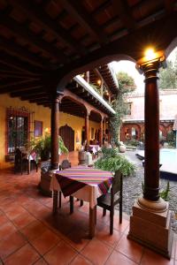 un patio al aire libre con una mesa y una lámpara en Hotel Palacio de Doña Beatriz, en Antigua Guatemala