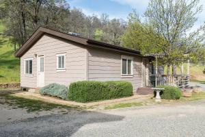 una pequeña casa blanca con techo en Homestead Cottages, en Ahwahnee