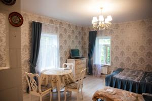 a bedroom with a table and a bed and a table and chairs at Lubas Apartment Monastery View in Kostroma