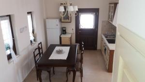 cocina con mesa, sillas y nevera en Kritamos Villa & Apartments, en Kamilari