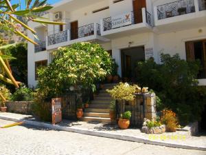 Una casa blanca con escaleras y plantas delante. en Samaria, en Agia Roumeli