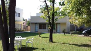 a yard with two chairs and a table in front of a building at La Quinta in Maipú