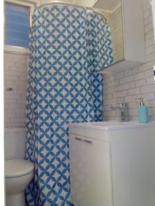 ロスピタレート・デ・リョブレガートにあるHUTB 013208のバスルーム(トイレ、青と白のシャワーカーテン付)