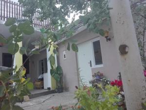 a small white house with flowers in front of it at Apartman Andjela 1 in Vrdnik