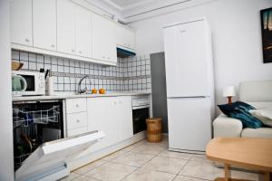 a kitchen with white cabinets and a white refrigerator at Costa del Silencio Apartment in Costa Del Silencio
