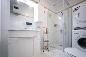 a bathroom with a shower and a sink and a washing machine at Costa del Silencio Apartment in Costa Del Silencio +24 photos