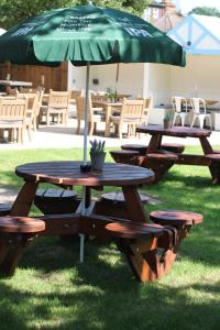 a picnic table with an umbrella on the grass at The Station in West Byfleet